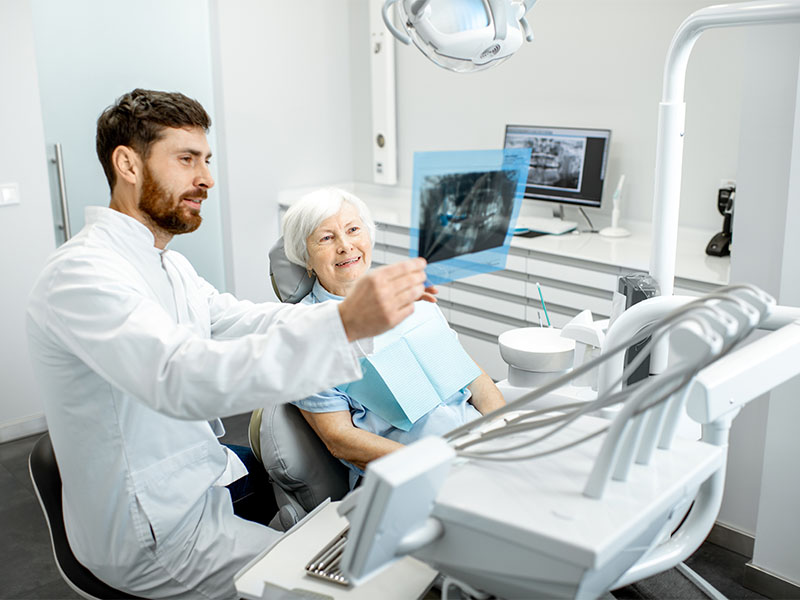Zahnarzt in Konstanz am Bodensee bespricht den Einsatz von Keramikkronen mit einer älteren Patientin