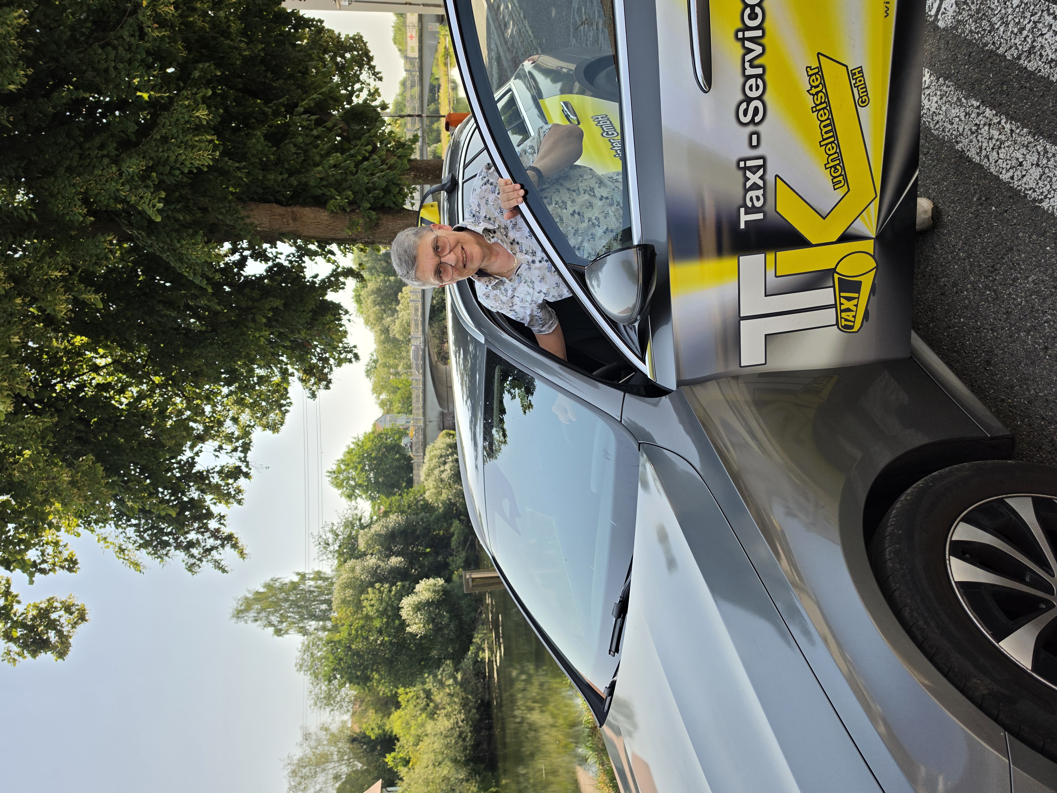 Geschäftsführerin Margit Kuchelmeister von Taxi-Service Kuchelmeister in Scheer mit Fahrzeugen des Unternehmens für Kranken- und Taxifahrten.