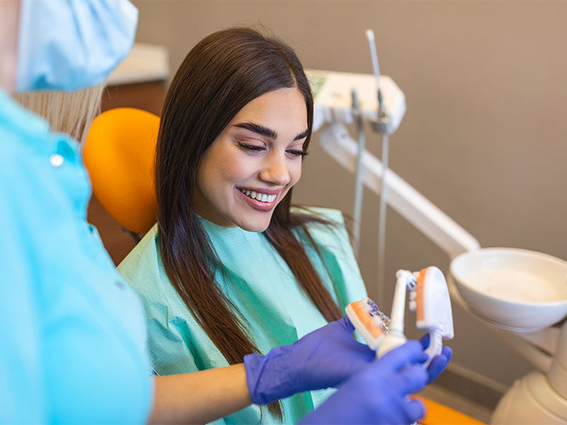 Patientin erhält in der MKG in Radolfzell eine Beratung zur Zahnbehandlung anhand eines Kiefermodells.