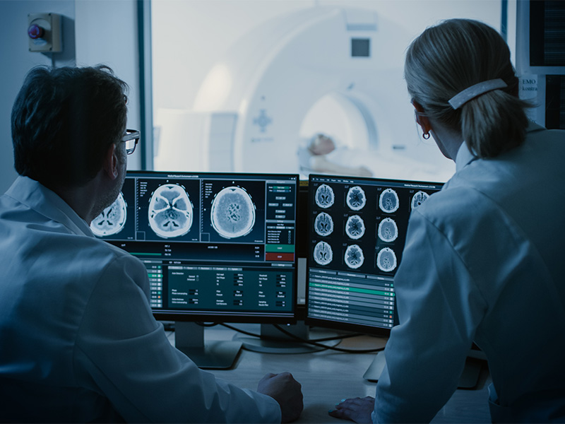 Ärztin und Radiologe besprechen medizinische Aufnahmen während einer Untersuchung im Umfeld der Strahlentherapie am Bodensee